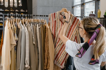Woman hanging shirt on rail in store